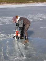 FWR student Heather Smith using chainsaw to cut hole in ice